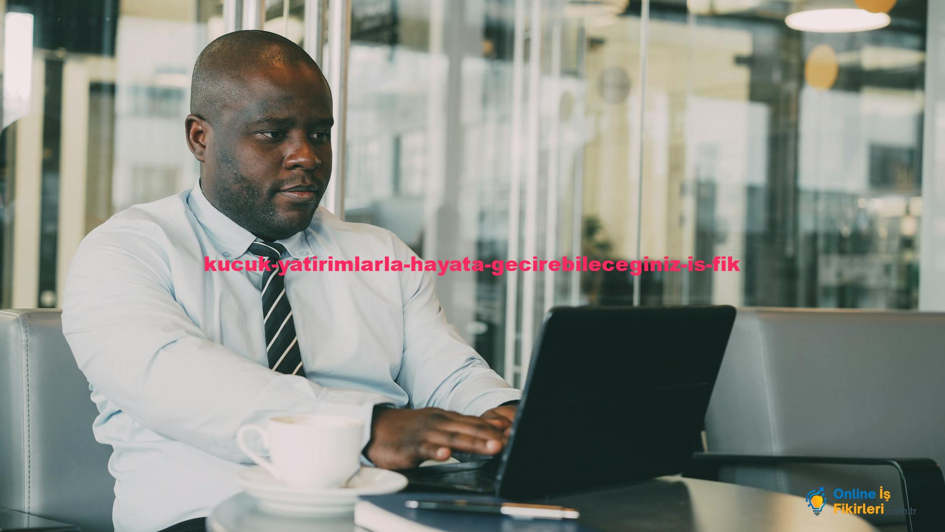 Businessman in cafe working on laptop with cup of coffee.